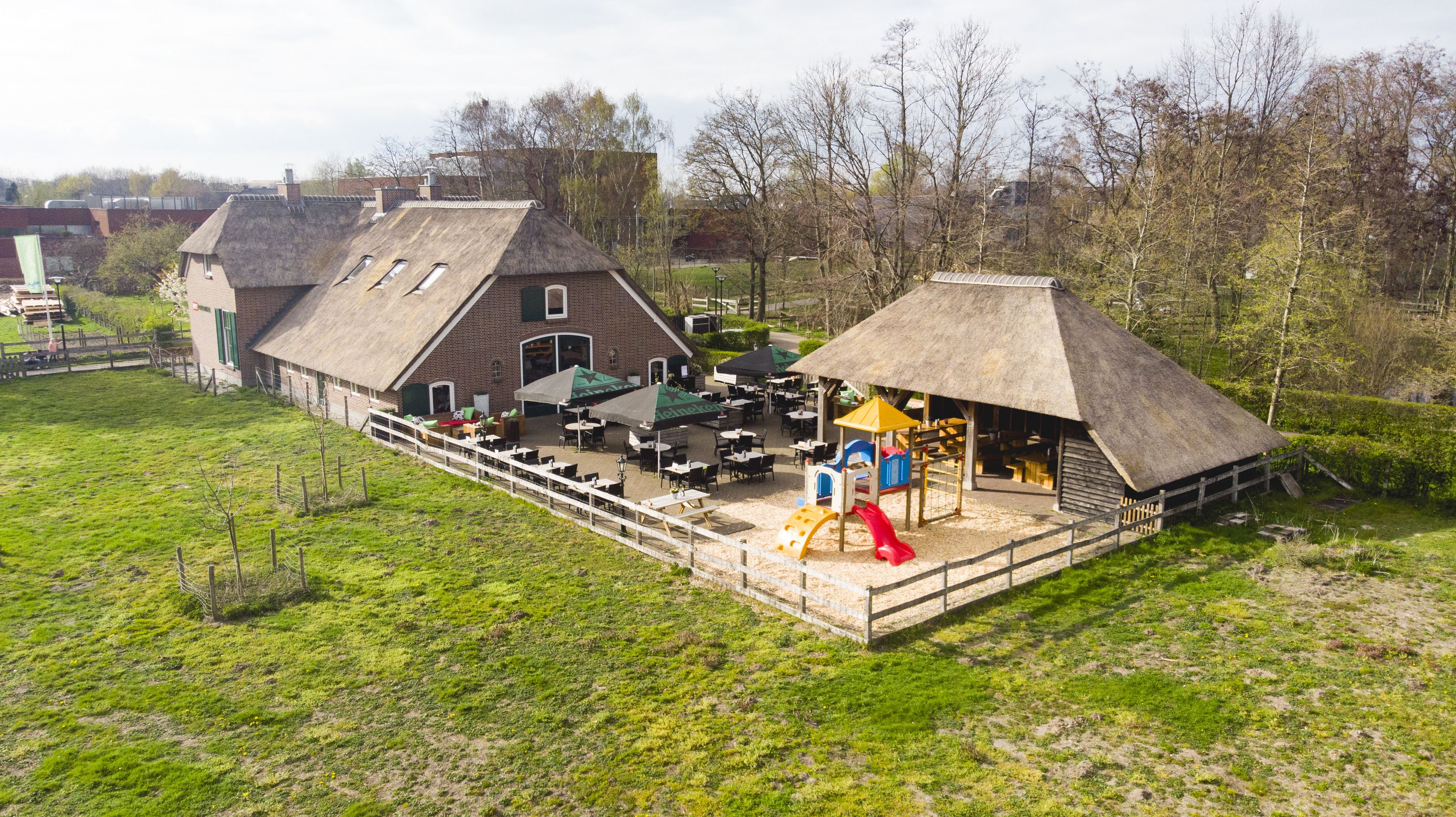 De boerderij van HEY!Pannenkoek vanuit de lucht, met het terras, de speeltuin en het groen eromheen